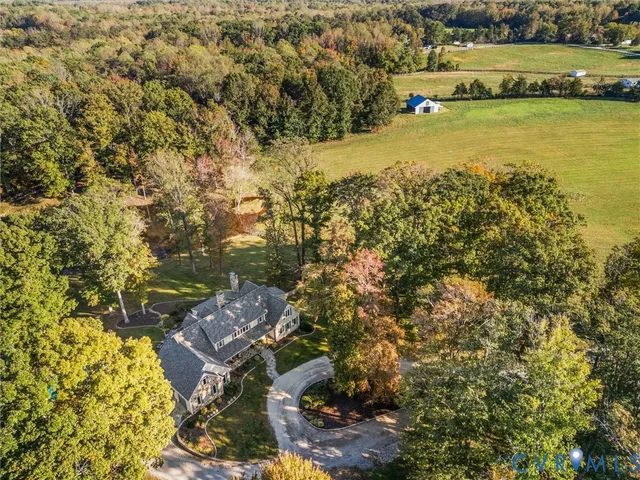 a view of a yard in front of a house with large trees