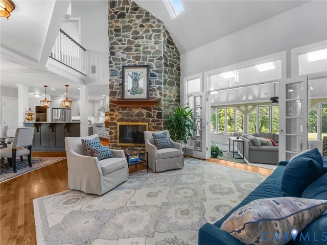 a bathroom with a granite countertop sink a large mirror a toilet and a window