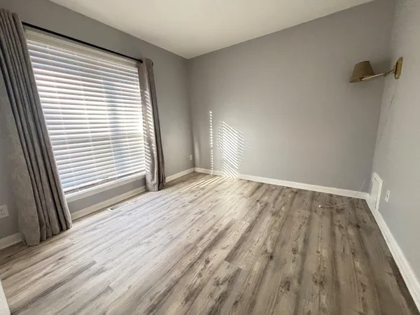 a view of a room with wooden floor and window