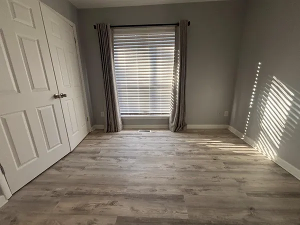 a view of wooden floor and staircase in back of a room
