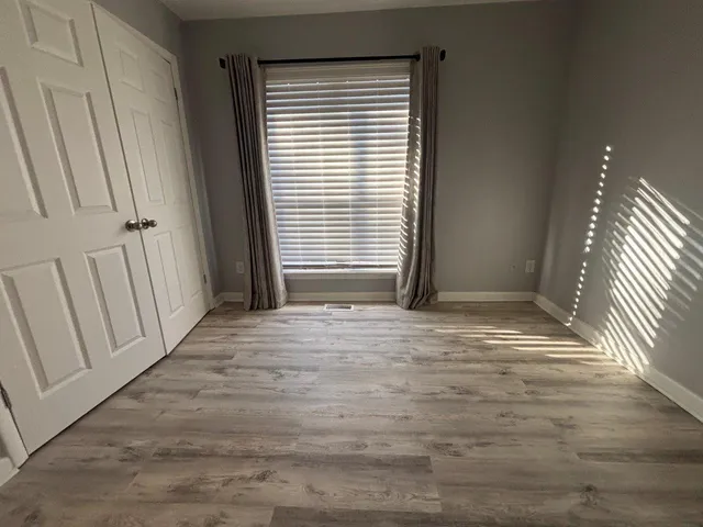 a view of wooden floor and staircase in back of a room