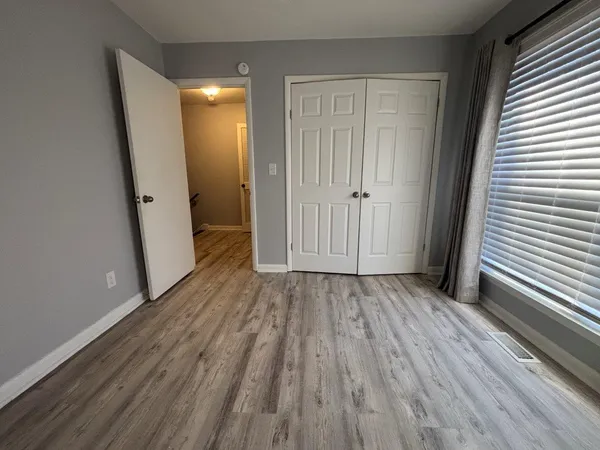 a view of a hallway with wooden floor and staircase