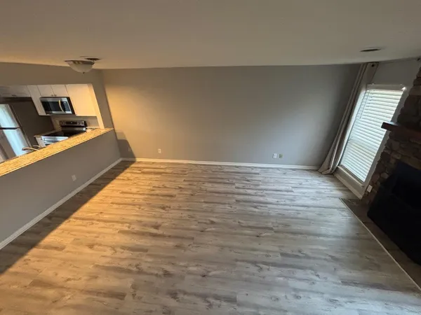 a view of an empty room and wooden floor