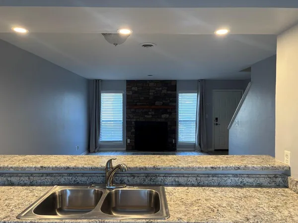 a kitchen with kitchen island granite countertop a sink and a stove