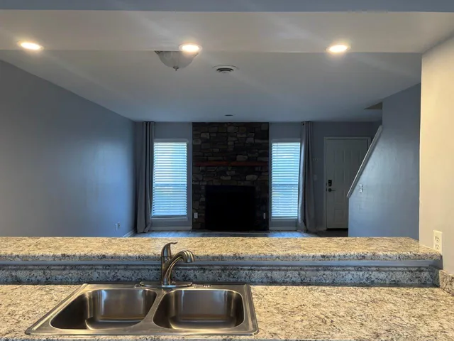 a kitchen with kitchen island granite countertop a sink and a stove