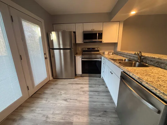 a kitchen with stainless steel appliances granite countertop a refrigerator stove and sink