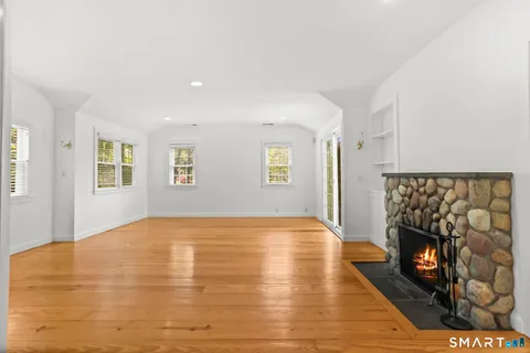 a view of an empty room with a window and fireplace