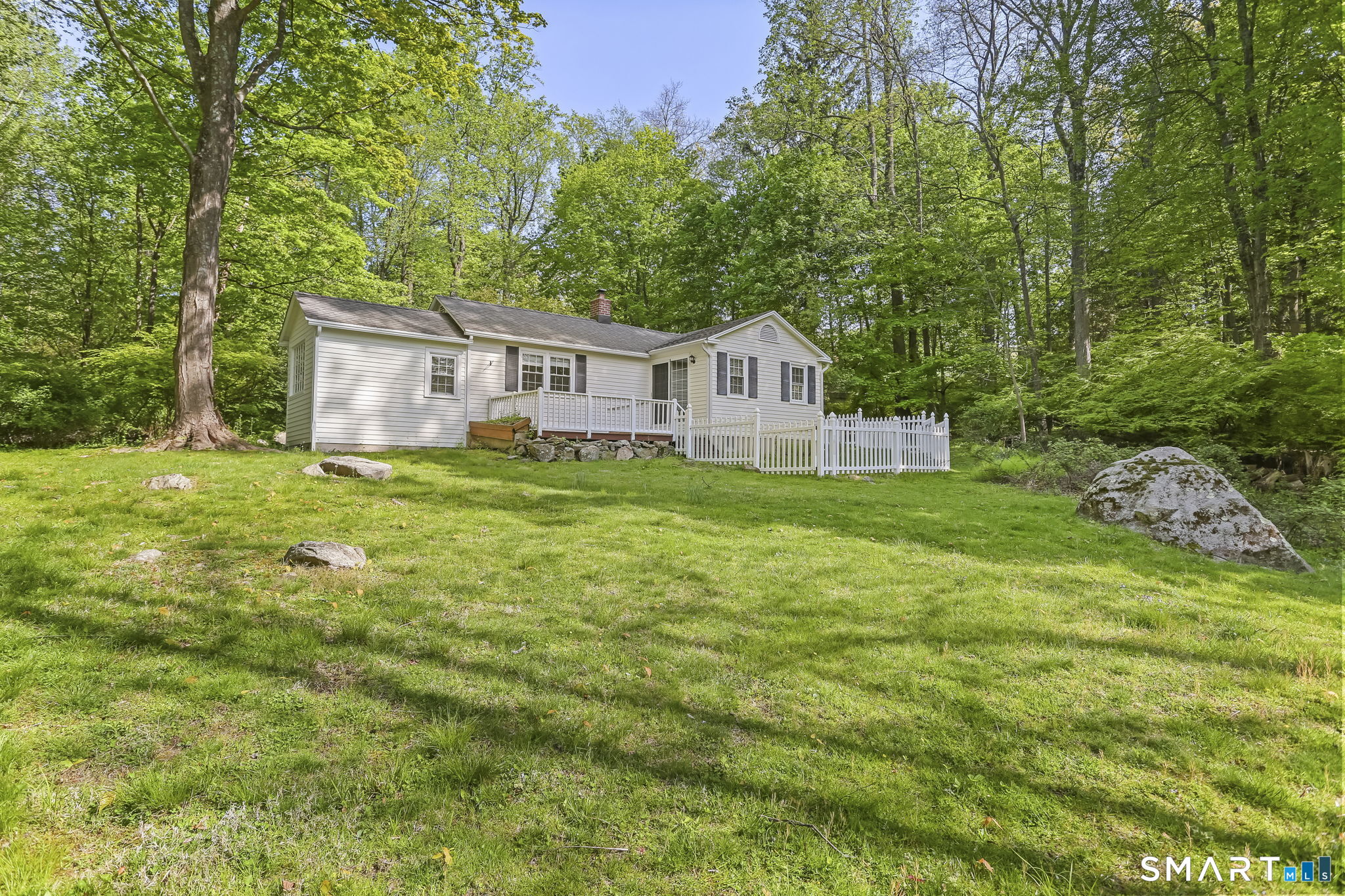 4 Topping Lane Norwalk, CT 06854 - Photo 2 of 30 a house that is sitting in the grass with large trees and plants