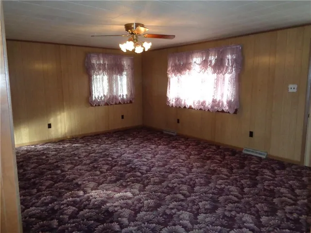a view of empty room with window ceiling fan and chandelier