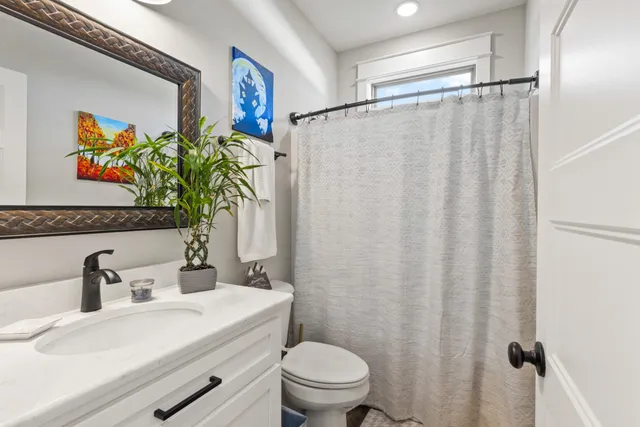 a bathroom with a sink mirror vanity and toilet