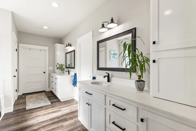 a spacious bathroom with double vanity and a mirror
