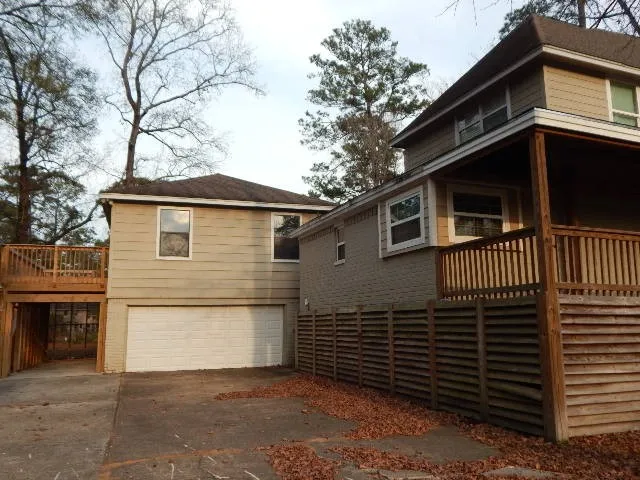 a view of a house with a yard and a large tree