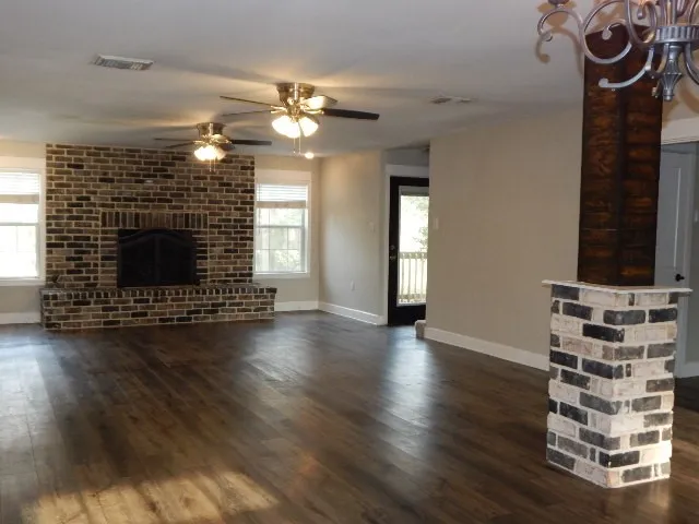 wooden floor fireplace and windows in an empty room