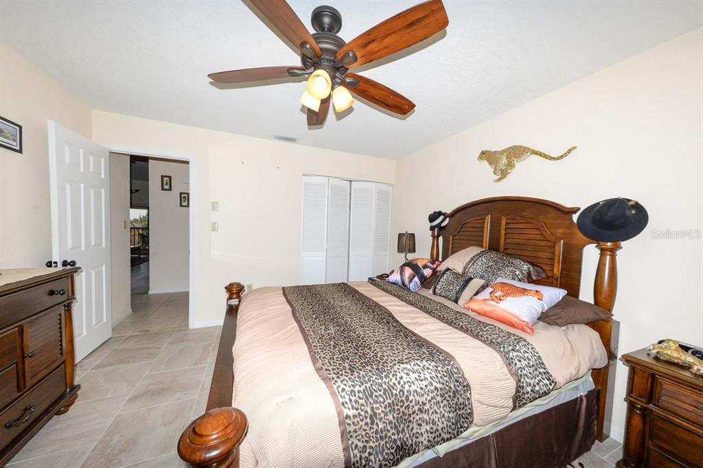 335 Coldeway Drive, Unit F21 Punta Gorda, FL 33950 - Photo 18 of 45 a bedroom with a bed and a chandelier