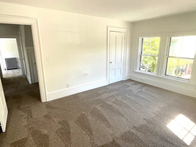 an empty room with windows and closet