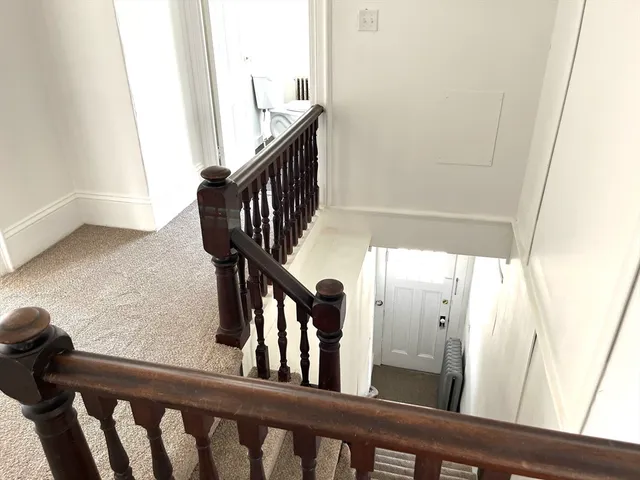 a view of staircase with railing and a window