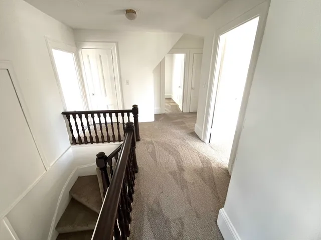 a view of a hallway and a livingroom with furniture