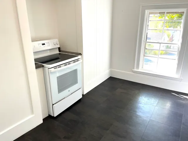 a view of a kitchen with wooden floor and electronic appliances