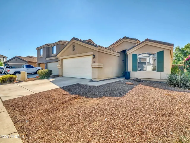 a view of a big house with a yard and large trees