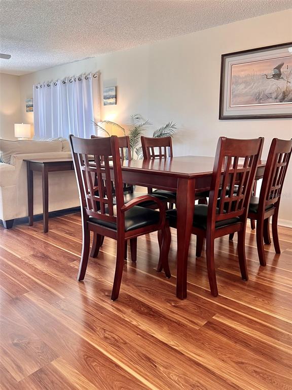 6501 Stone River Road, Unit 203 Bradenton, FL 34203 - Photo 9 of 45 a view of a dining room with furniture and wooden floor