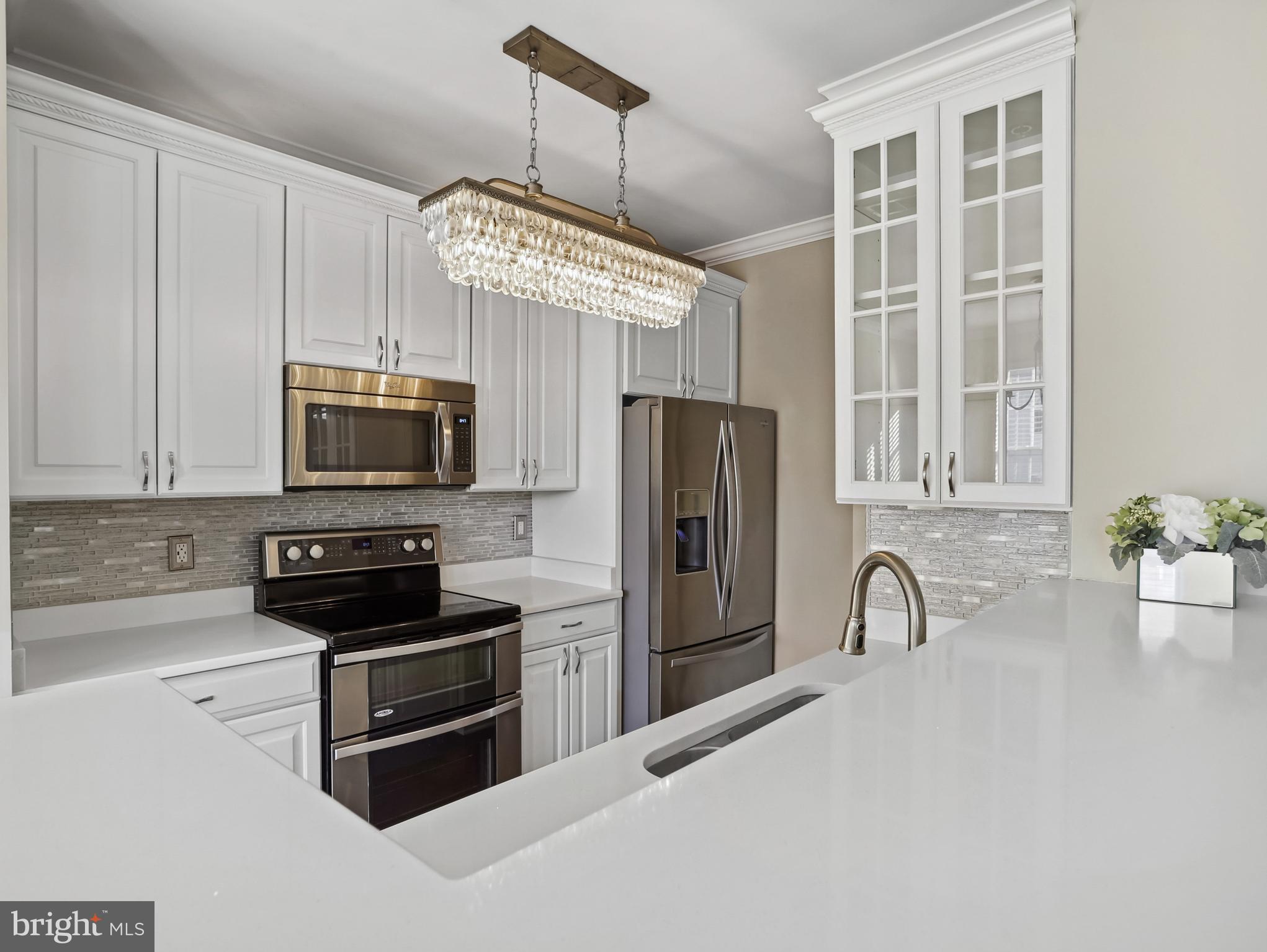 a kitchen with stainless steel appliances a stove a sink a microwave and cabinets