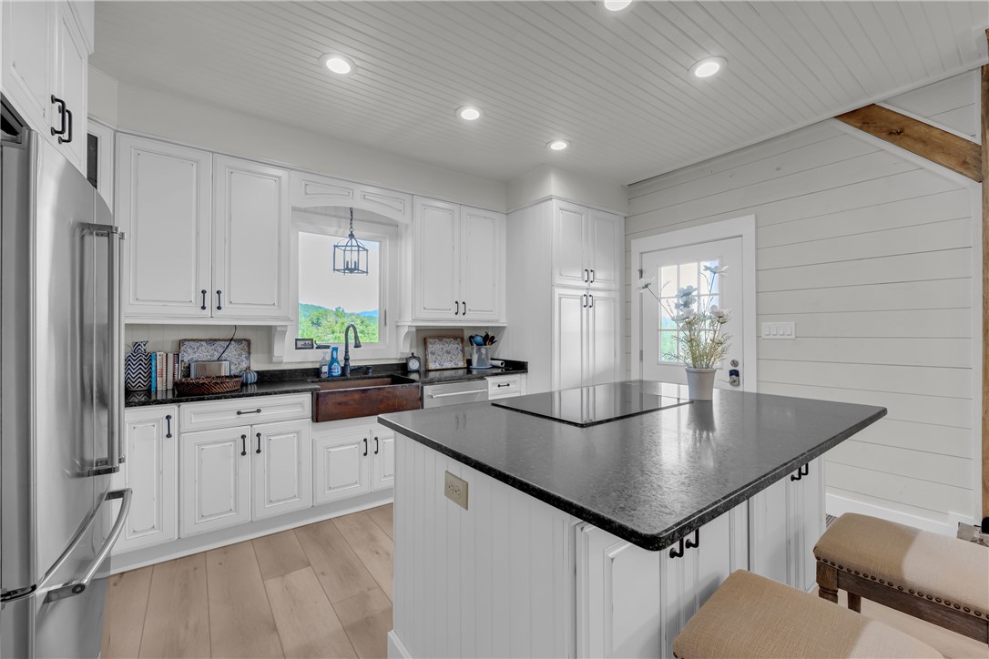 498 Raines Road Mountain Rest, SC 29664 - Photo 37 of 48 Shiplap accents and wood floors bring warmth to this custom kitchen with a central island.