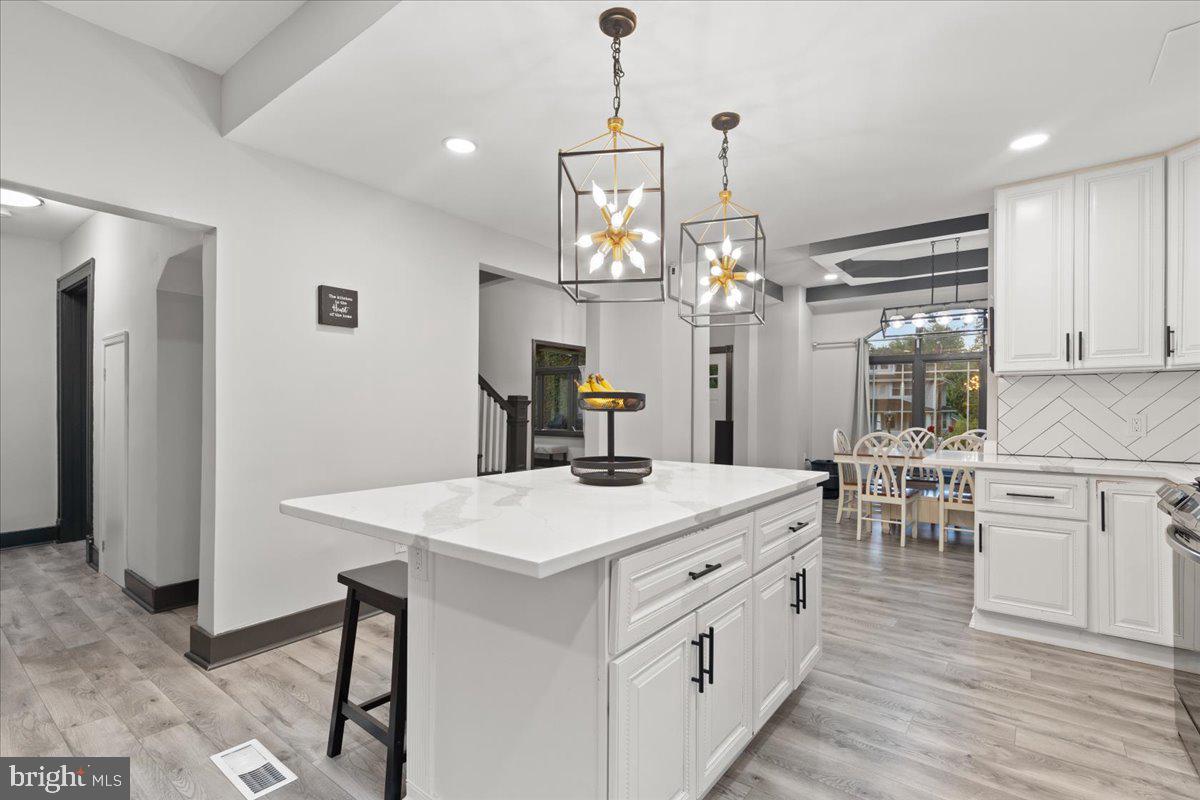 3910 Chatham Road Baltimore, MD 21207 - Photo 18 of 71 a kitchen that has a lot of white cabinets and stainless steel appliances