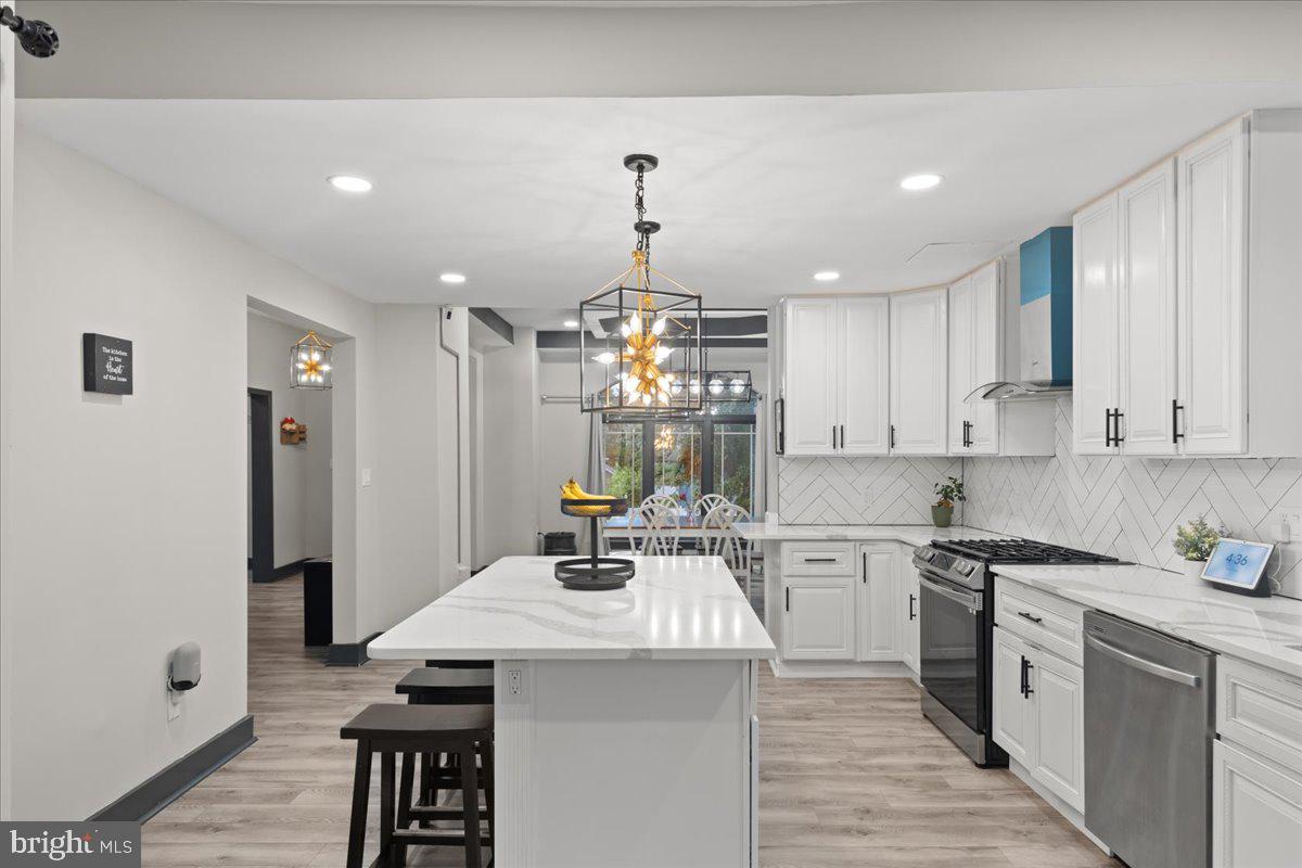 3910 Chatham Road Baltimore, MD 21207 - Photo 19 of 71 a kitchen that has a lot of white cabinets and stainless steel appliances