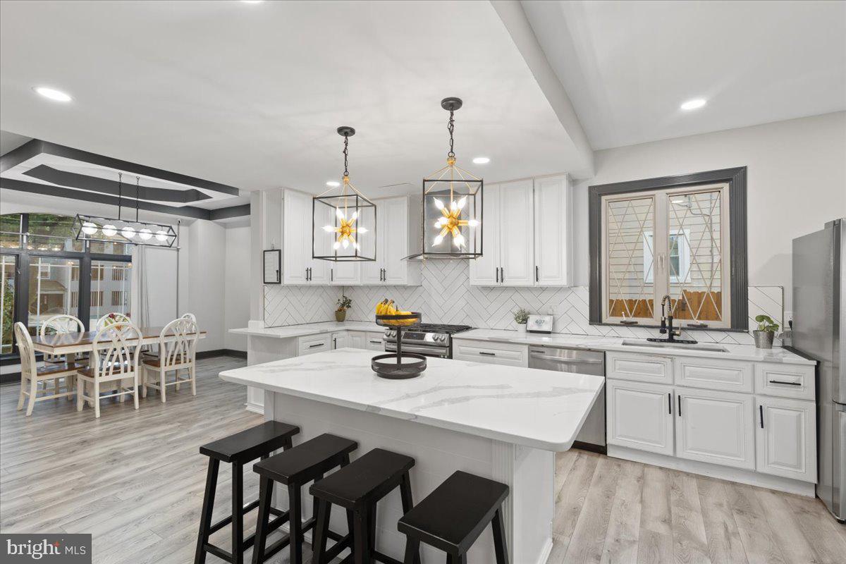 3910 Chatham Road Baltimore, MD 21207 - Photo 20 of 71 a kitchen with a dining table chairs sink and cabinets
