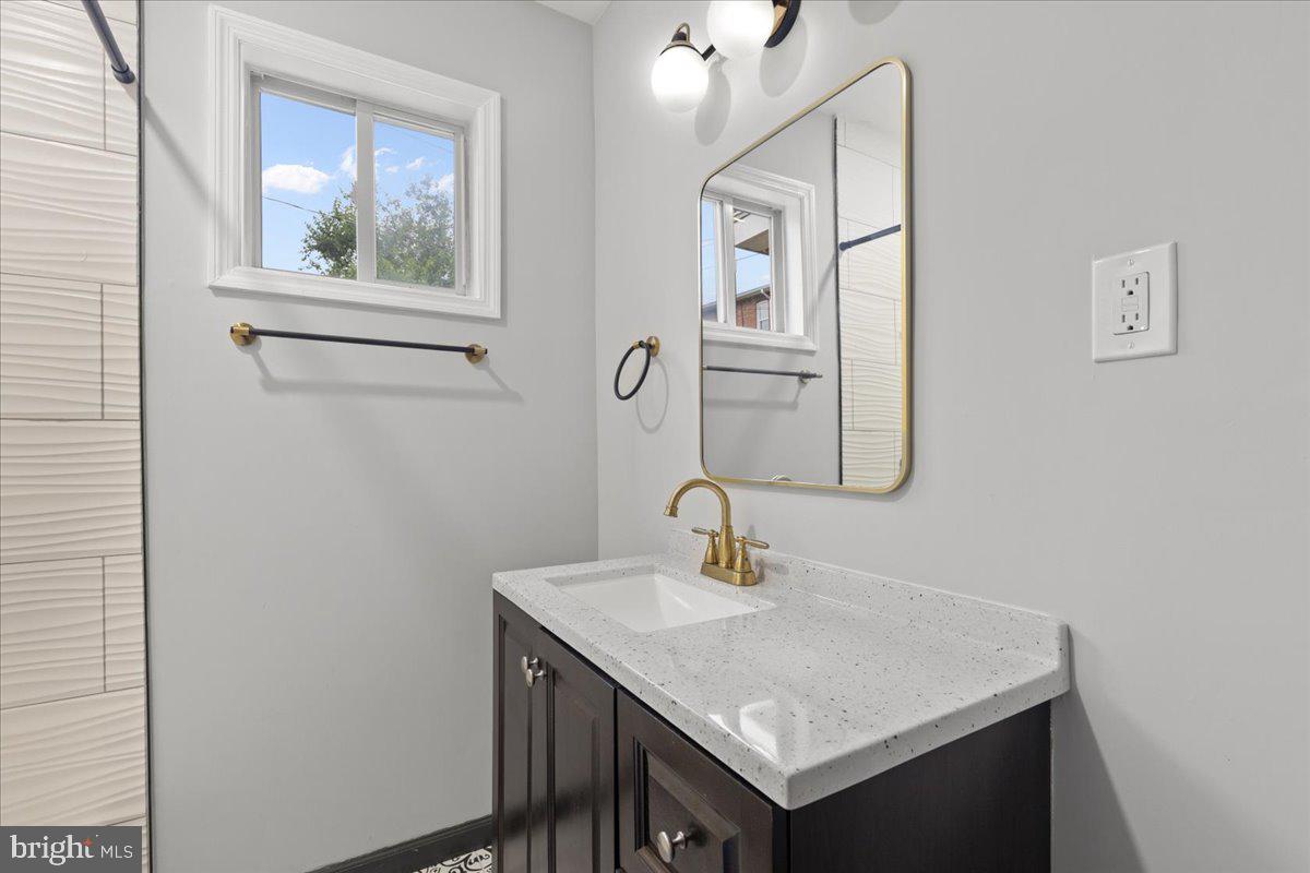 3910 Chatham Road Baltimore, MD 21207 - Photo 24 of 71 a bathroom with a sink a mirror and a window