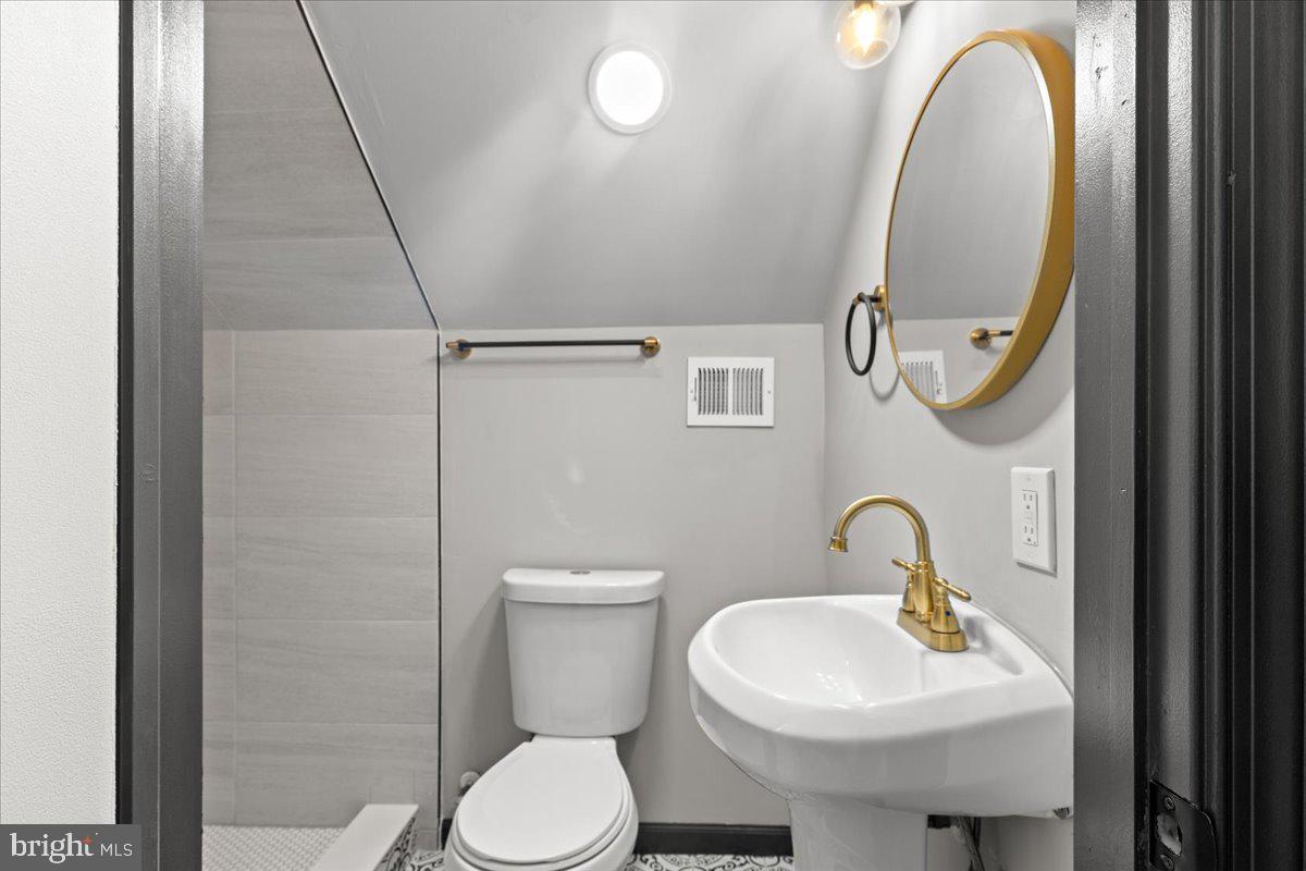 3910 Chatham Road Baltimore, MD 21207 - Photo 46 of 71 a bathroom with a toilet sink and mirror