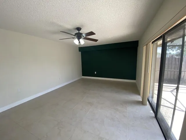 a view of a livingroom with a ceiling fan and window