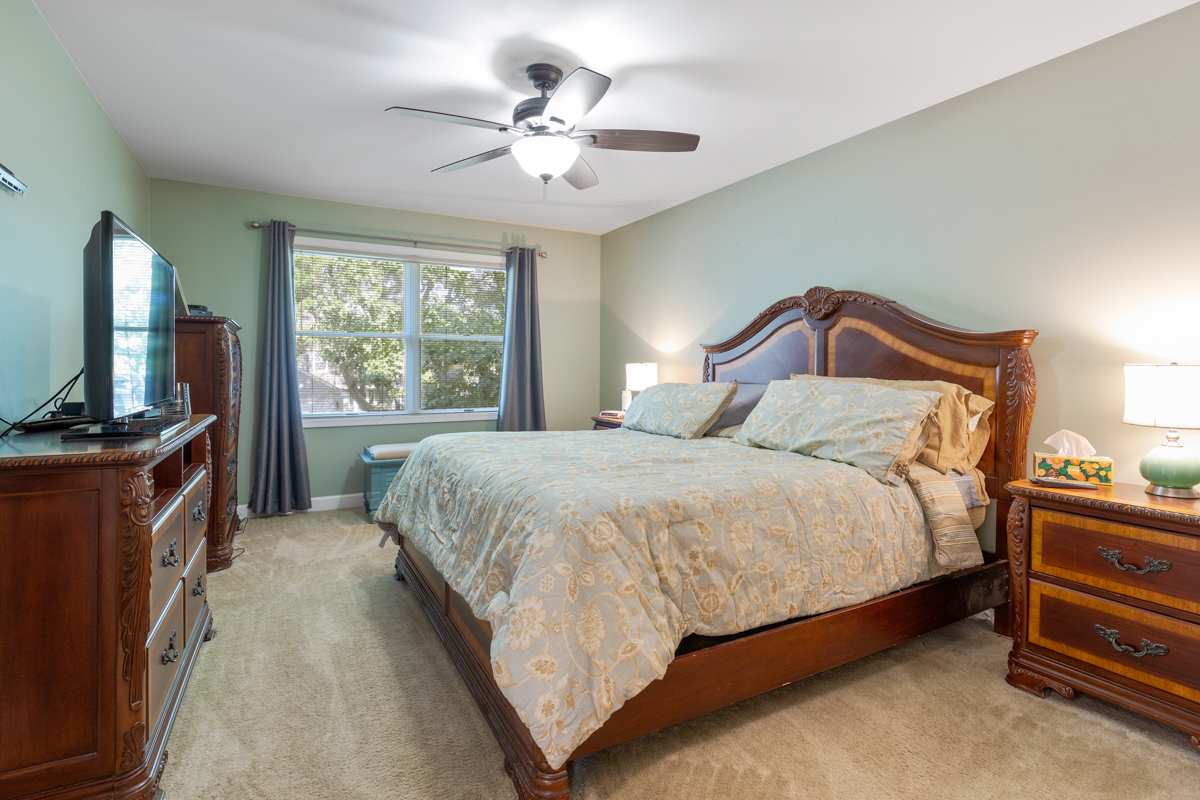 2225 Forest Ridge Road St. Charles, IL 60174 - Photo 13 of 24 a spacious bedroom with a bed and a flat tv screen on dresser