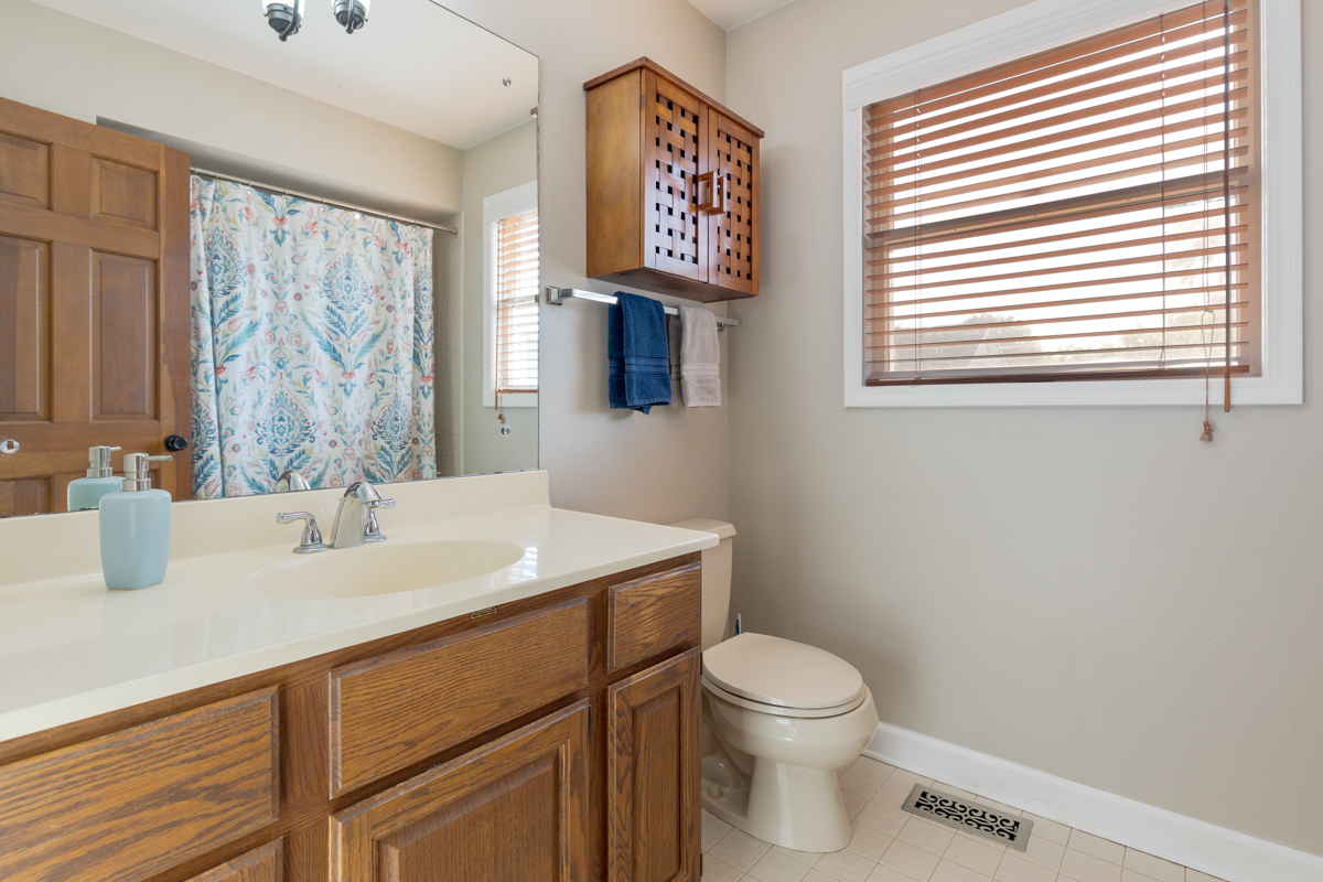 2225 Forest Ridge Road St. Charles, IL 60174 - Photo 16 of 24 a bathroom with a toilet a sink and a large mirror