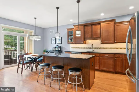a kitchen with stainless steel appliances granite countertop wooden floor window and cabinets
