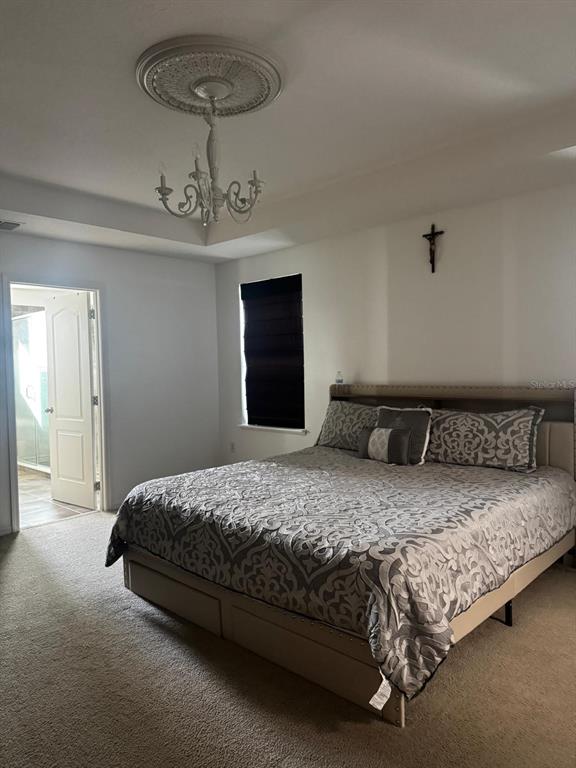 3837 Spring Creek Road Dundee, FL 33838 - Photo 5 of 13 a bedroom with a bed and a chandelier