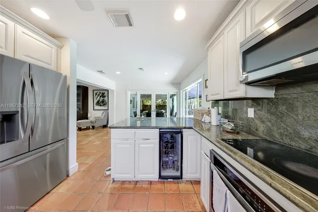 a kitchen with stainless steel appliances granite countertop a refrigerator and a stove