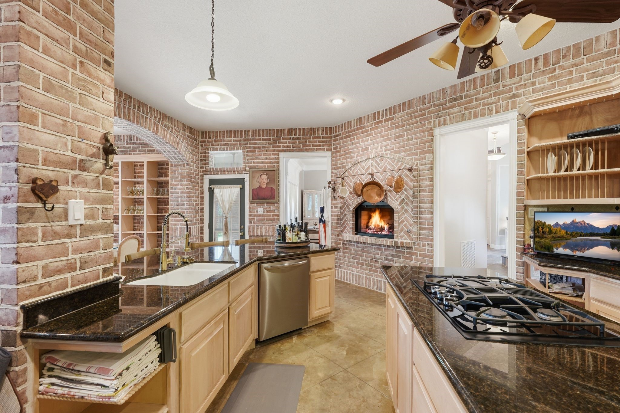 25014 Northampton Terrace Drive Spring, TX 77389 - Photo 9 of 41 Gaslog fireplace enhances the charm of the kitchen, as well as the custom stained flooring, so many details in this kitchen to mention! You have to come see it for yourself