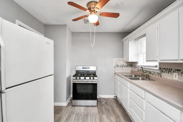 a kitchen with stainless steel appliances a refrigerator sink and white cabinets