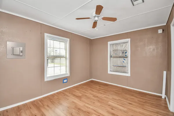 a view of an empty room with a window and wooden floor