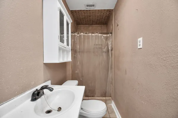 a bathroom with a sink a toilet and shower