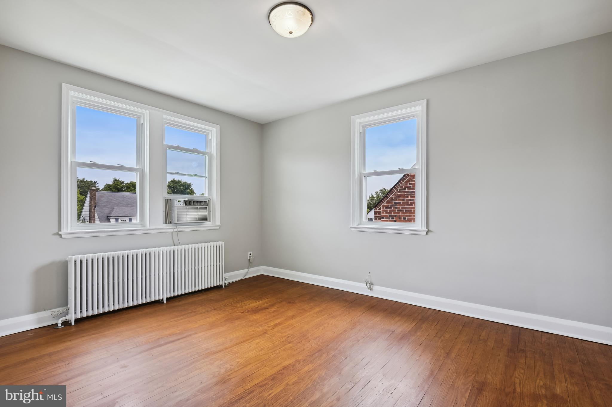 722 Braeside Road Baltimore, MD 21229 - Photo 20 of 30 a view of an empty room with wooden floor and a window