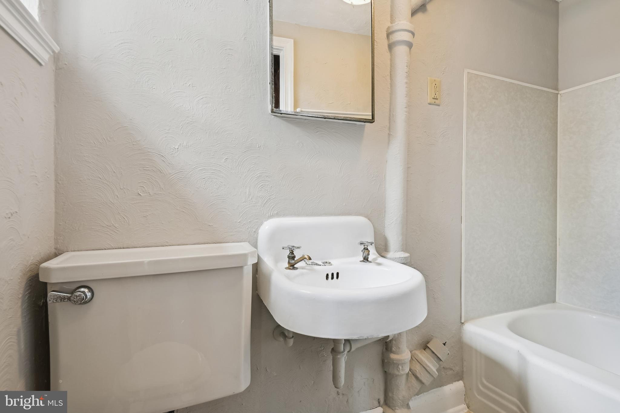 722 Braeside Road Baltimore, MD 21229 - Photo 29 of 30 a bathroom with a sink a toilet and mirror