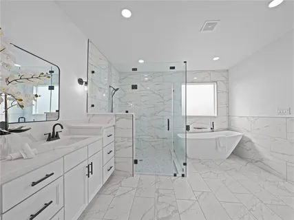 a bathroom with a granite countertop sink mirror and bathtub