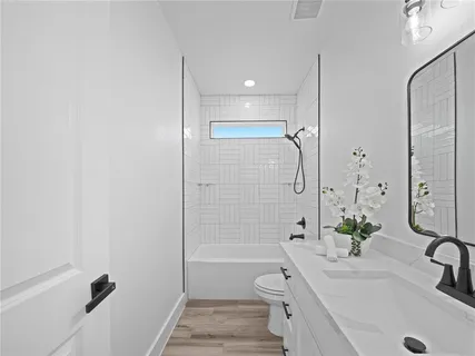 a bathroom with a tub sink toilet and a mirror