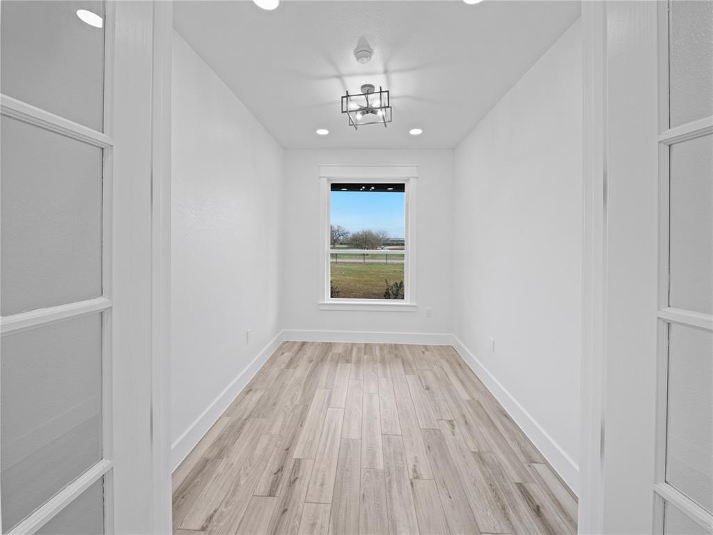 145 Cartwright Park Road Weatherford, TX 76087 - Photo 19 of 27 a view of an empty room with wooden floor and a window