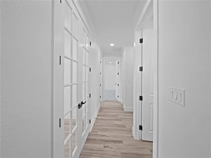 a view of a hallway with wooden floor and staircase