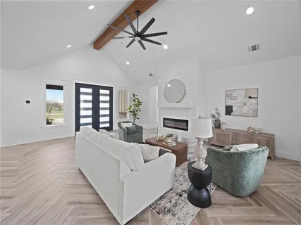 a living room with furniture a fireplace and a ceiling fan