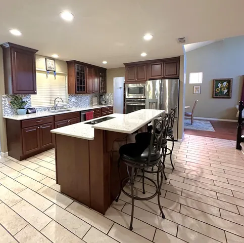 a kitchen with stainless steel appliances kitchen island granite countertop a sink and cabinets