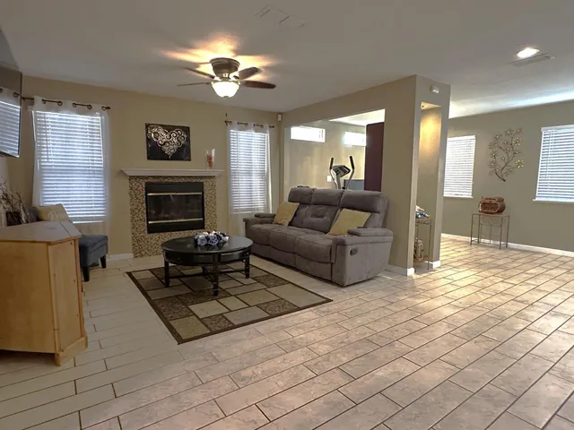 a living room with furniture a large window and a fireplace